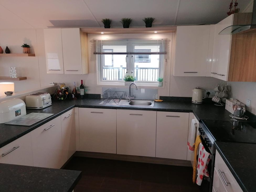 A kitchen with sink and appliances at Seaside Lodge Retreat in Eyemouth