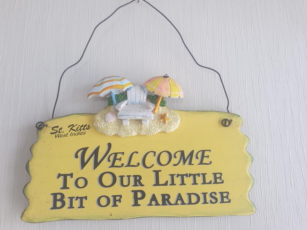 A decorative sign with welcome message at Seaside Lodge Retreat in Eyemouth