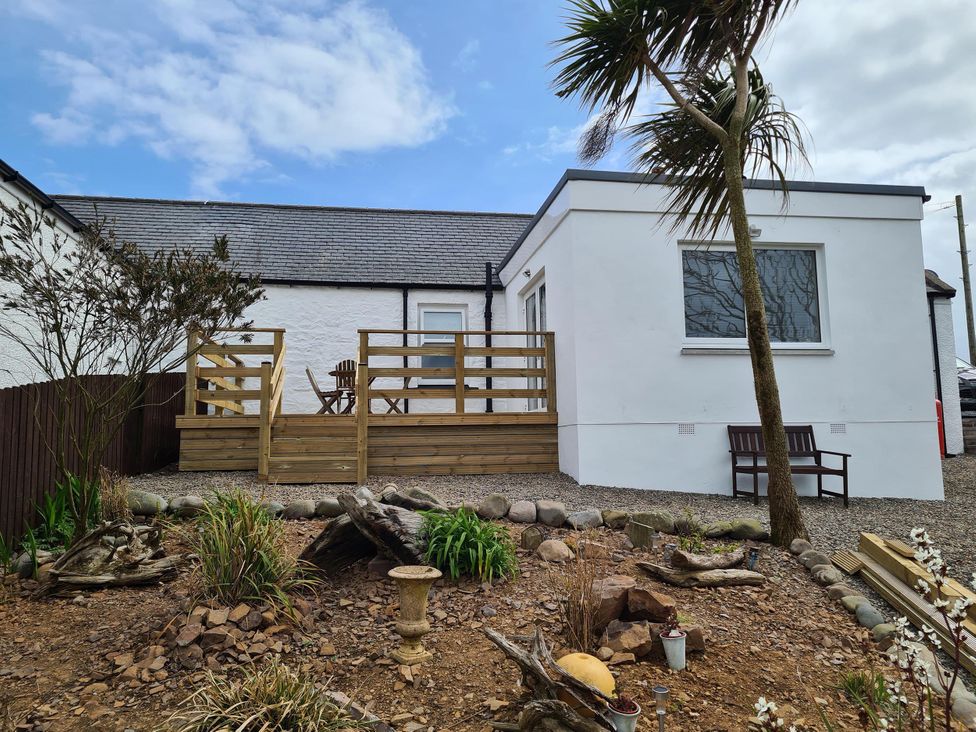 An outdoor area with a wooden deck and seating at Beautiful 2Bed semi rural cottage enclosed garden in Stranraer