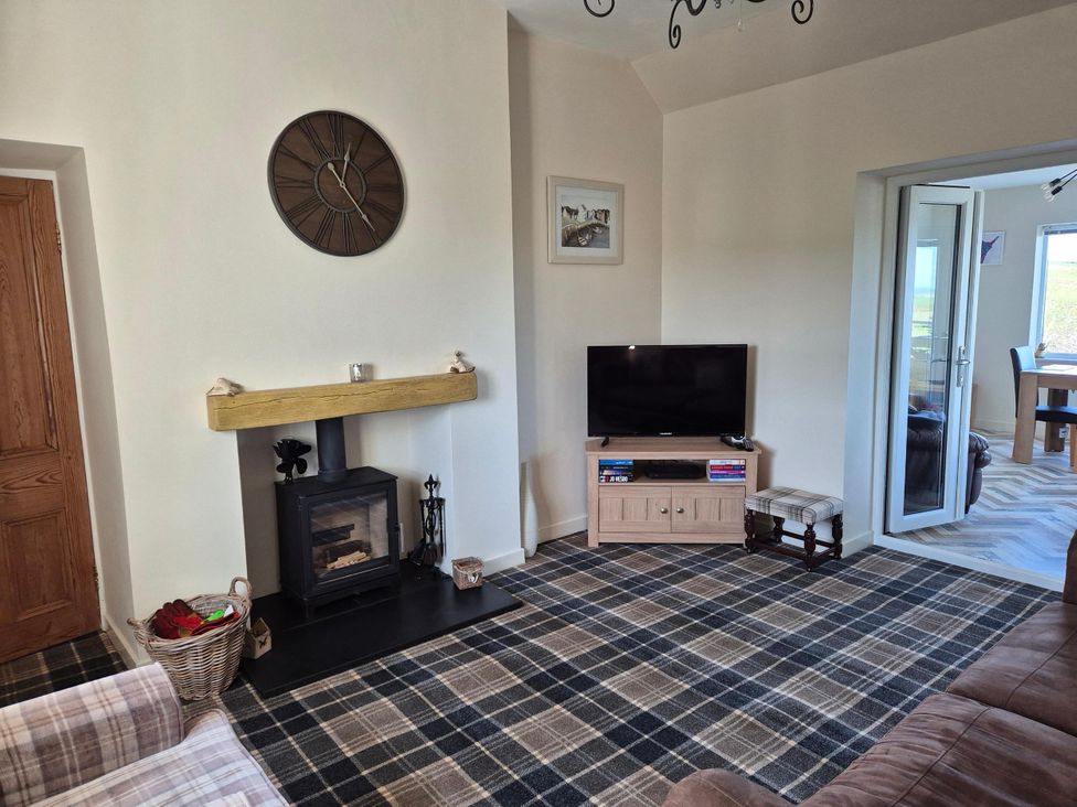 A living room with a fireplace and television at Beautiful 2Bed semi rural cottage enclosed garden in Stranraer