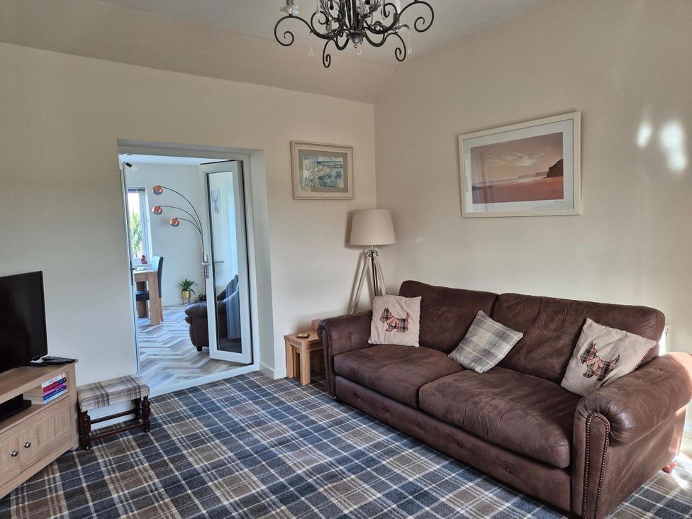 A living room with a sofa and television at Beautiful 2Bed semi rural cottage enclosed garden Stranraer