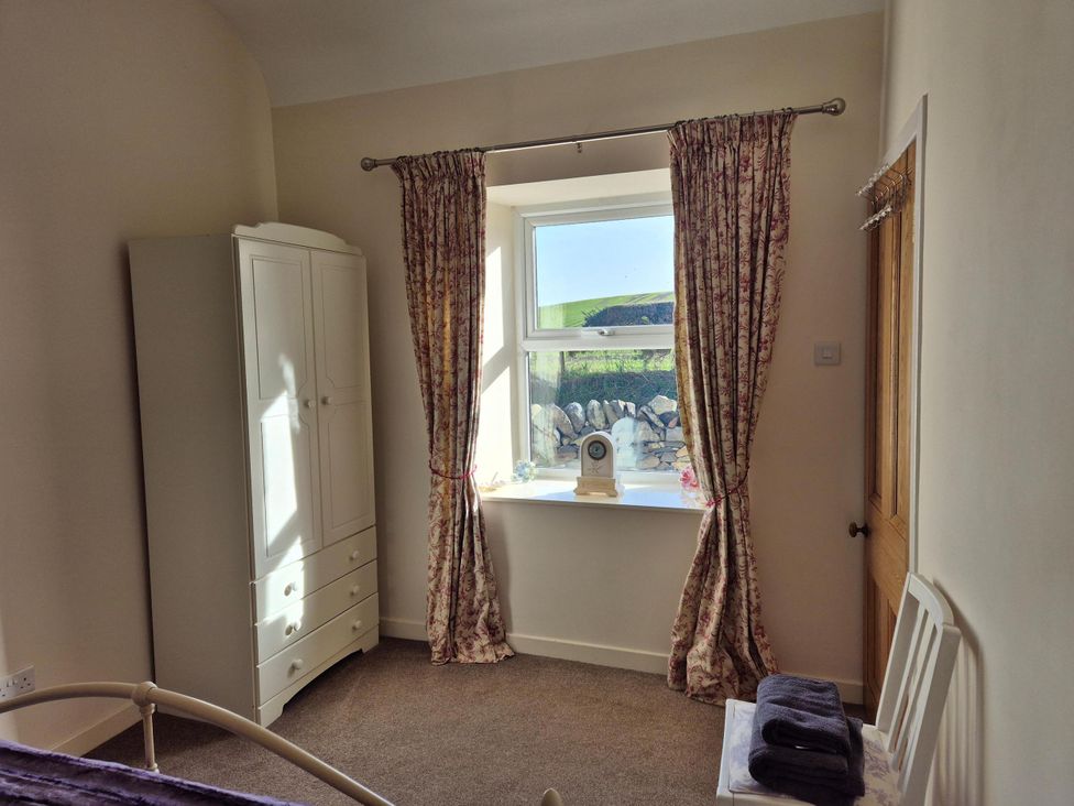 A bedroom with a wardrobe and window at Beautiful 2Bed semi rural cottage enclosed garden Stranraer