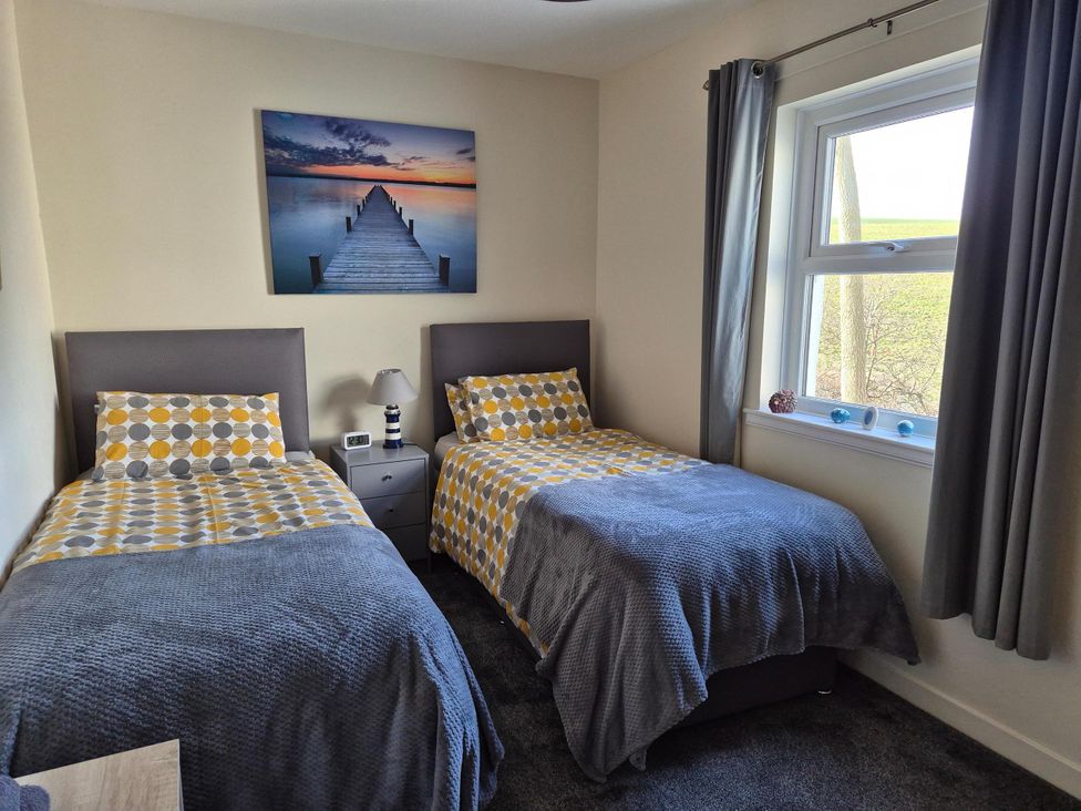 A bedroom with two beds and a picture on the wall at Beautiful 2Bed semi rural cottage enclosed garden Stranraer