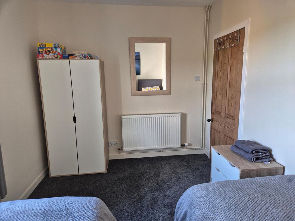 A bedroom with a wardrobe, mirror, and towels at Beautiful 2Bed semi rural cottage enclosed garden Stranraer