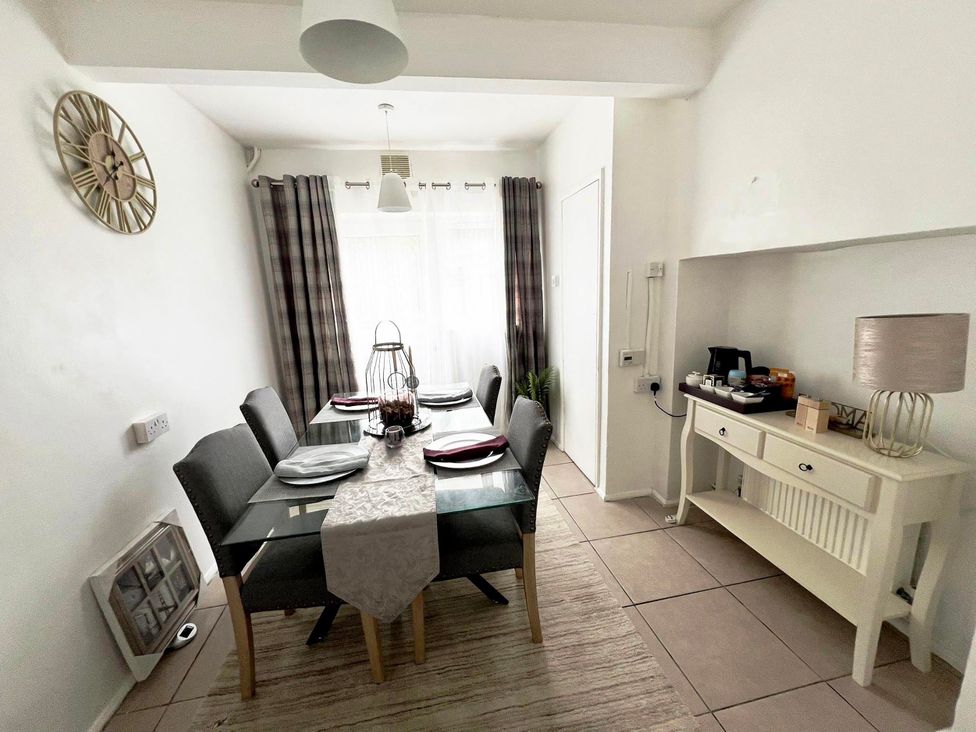 A dining room with a table and chairs at Suspire House Sleeps 6 Garden Bbq Coastal retreat Near Valley