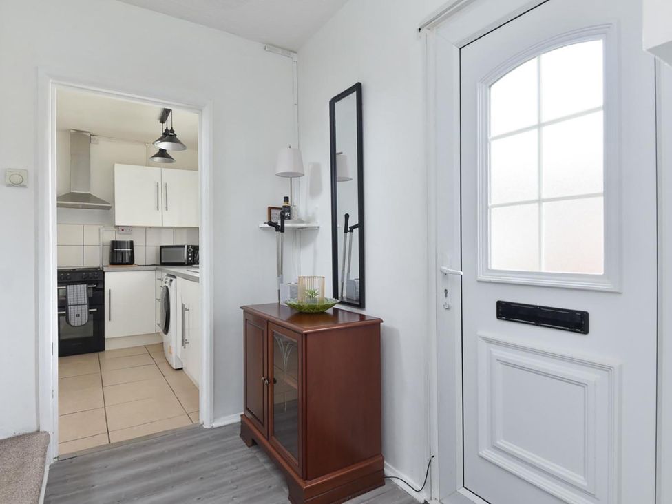 A hallway with a console table and a door leading to the kitchen at Suspire House Sleeps 6 Garden Bbq Coastal retreat Near Valley