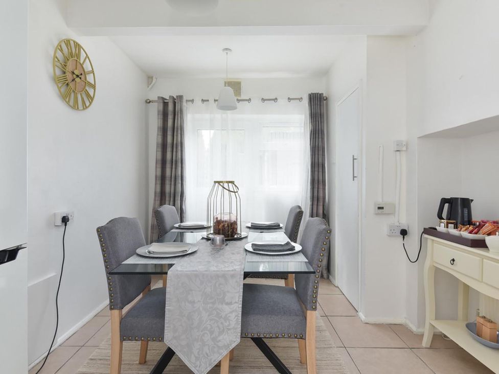A dining room with a table and chairs at Suspire House Sleeps 6 Garden Bbq Coastal retreat Near Valley