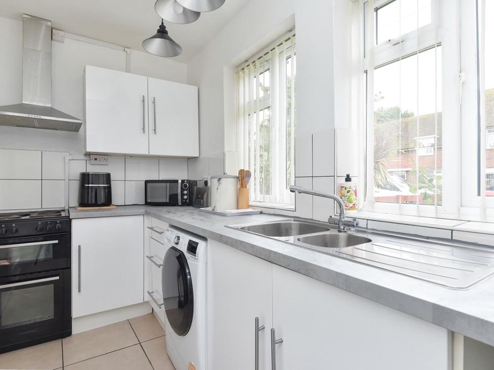 A kitchen with appliances and cabinets at Suspire House Sleeps 6 Garden Bbq Coastal retreat Near Valley