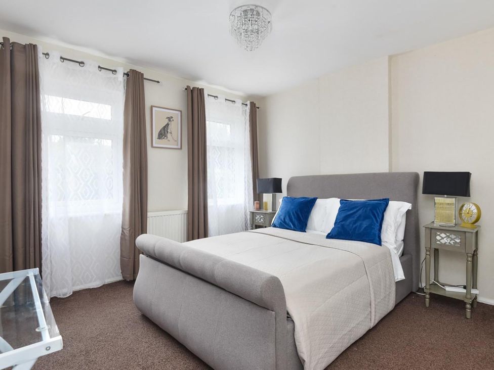 A bedroom with a bed and bedside tables at Suspire House Sleeps 6 Garden Bbq Coastal retreat Near Valley