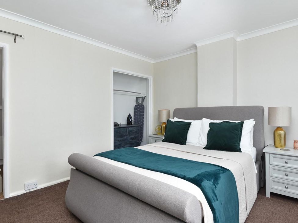 A bedroom with a bed and wardrobe at Suspire House Sleeps 6 Garden Bbq Coastal retreat Near Valley