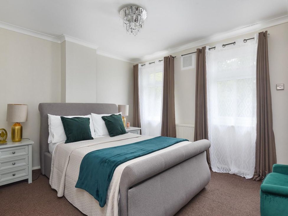 A bedroom with a bed and bedside table at Suspire House Sleeps 6 Garden Bbq Coastal retreat Near Valley