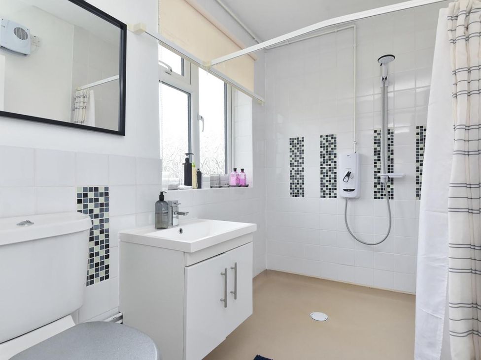 A bathroom with a sink shower toilet and mirror at Suspire House Sleeps 6 Garden Bbq Coastal retreat Near Valley