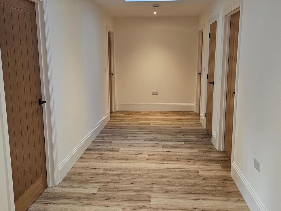 A hallway with doors on either side at Luxury Kent Bungalow Retreat Sleeps 12 Cross-at-Hand near Staplehurst
