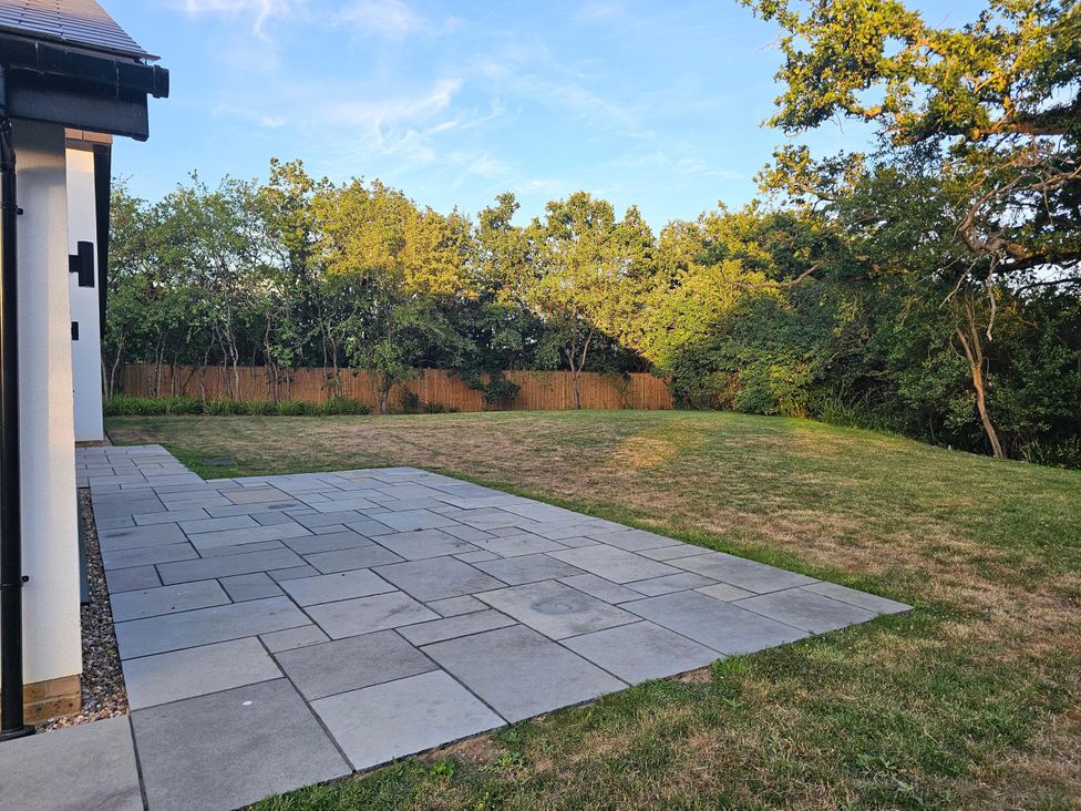 A garden with a paved patio and grass at Luxury Kent Bungalow Retreat Sleeps 12 Cross-at-Hand near Staplehurst