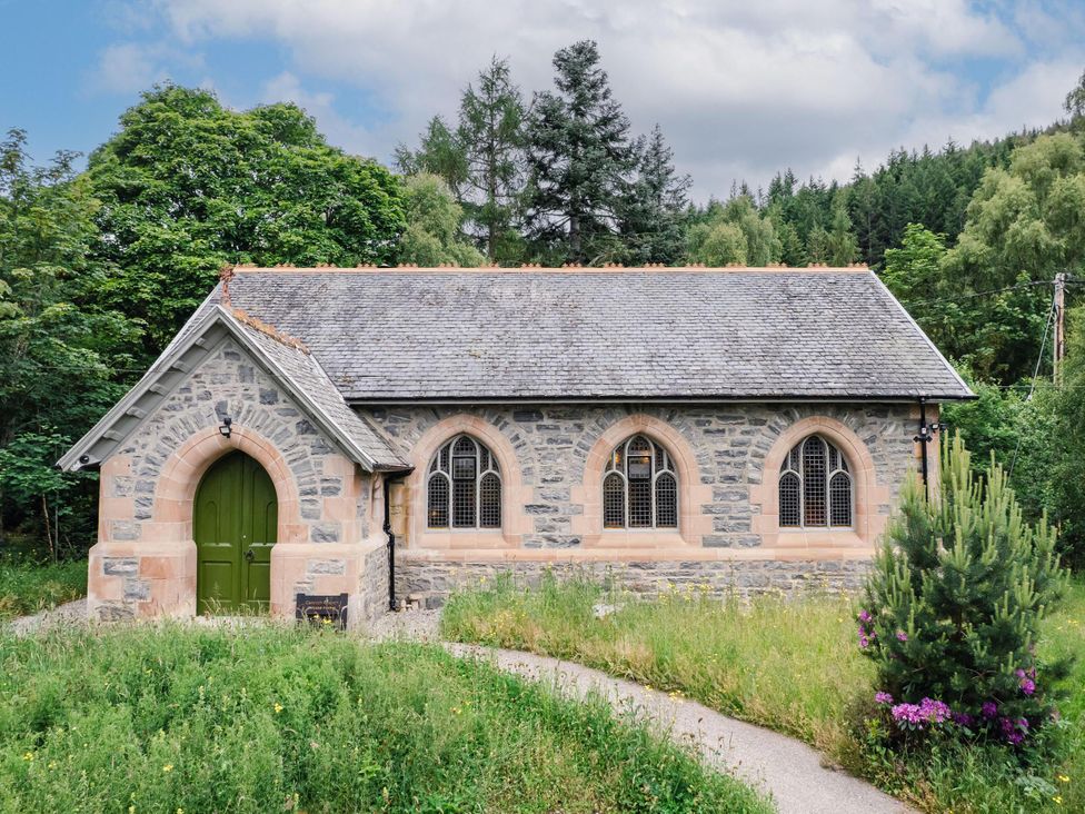 A church building with a green door and stone exterior at Grade C Church in Cannich