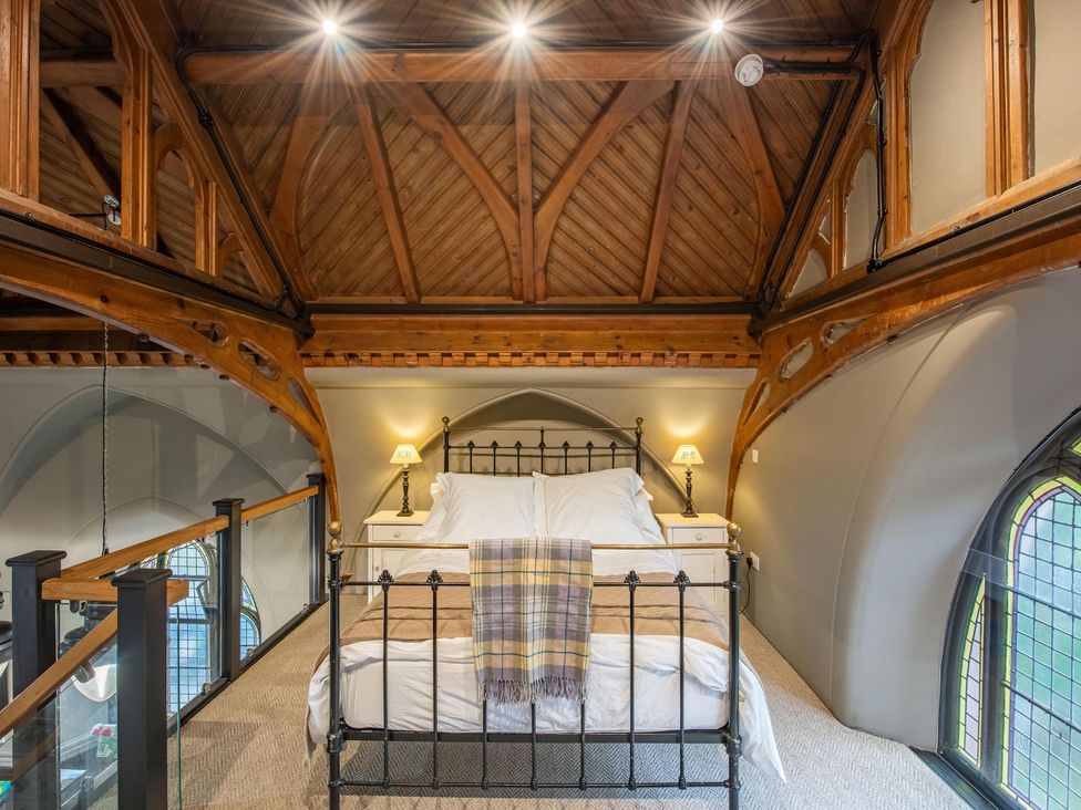 A bedroom with a bed and bedside lamp at Grade C Church in Cannich