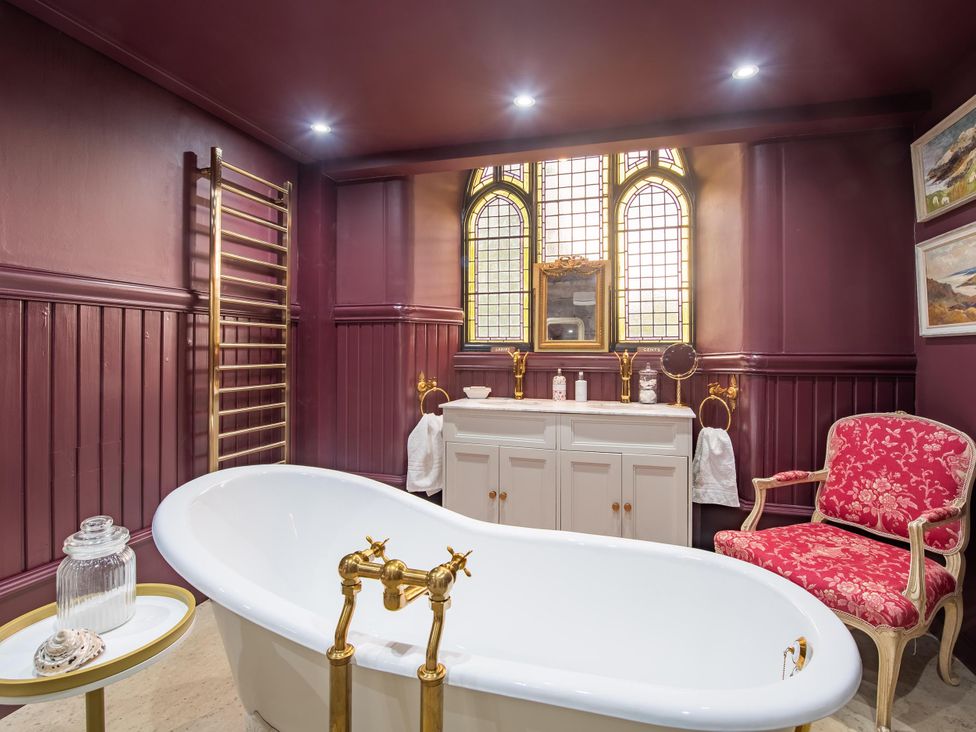 A bathroom with a bathtub and vanity at Grade C Church in Cannich Sleeps 2 Parking in Cannich