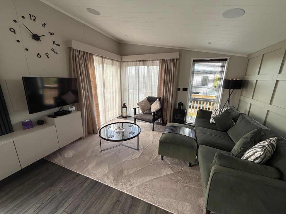 A living room with a clock and television at Malton 2Bed Lodge Sleeps 4 Pet Friendly in Malton