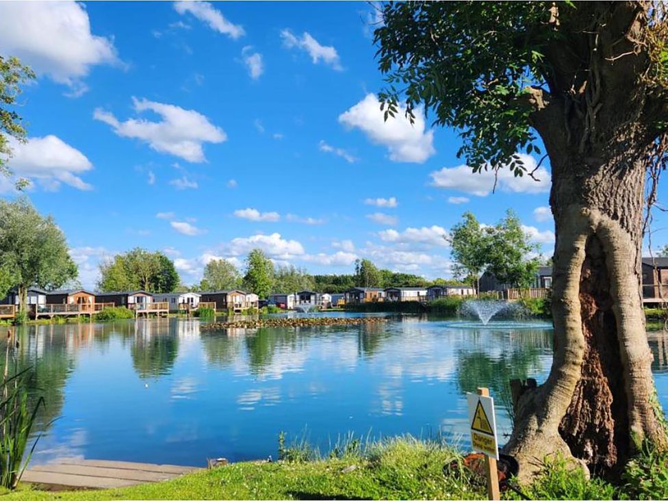 A lake with cabins and a tree at Malton 2Bed Lodge Sleeps 4 Pet Friendly in Malton