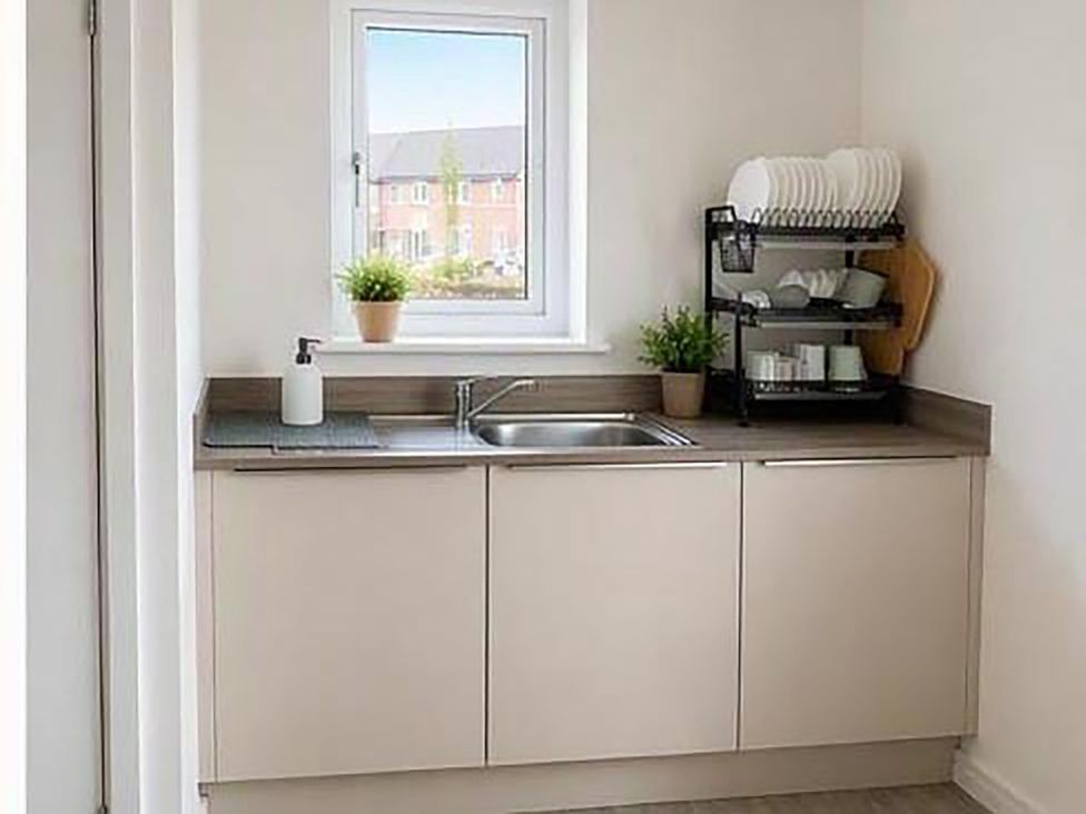 A kitchen with a sink and a dish rack at the property in location