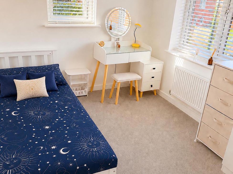 A bedroom with a bed and vanity desk at the property in the location