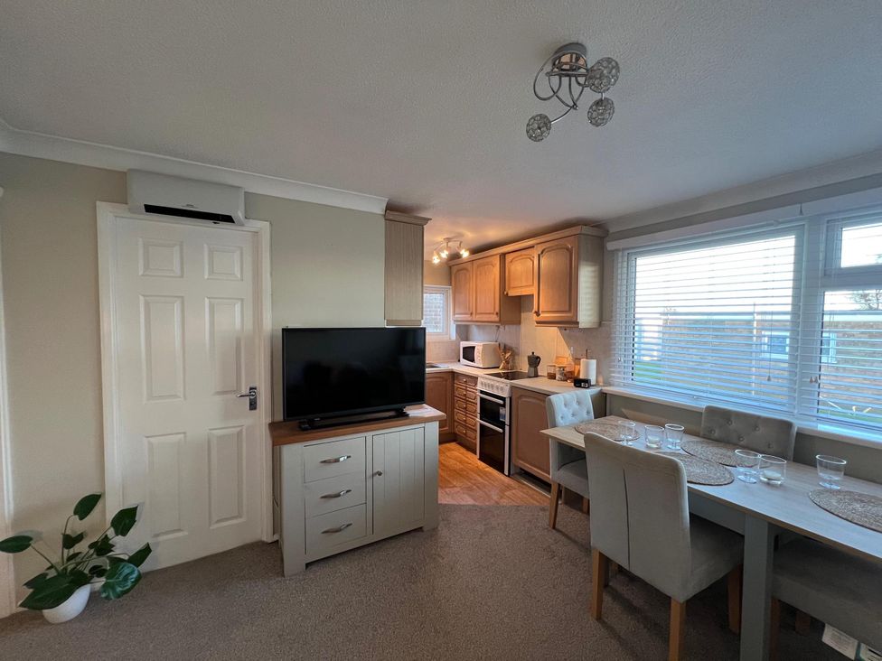 A kitchen with a tv and dining area at The Old Barn in Manchester