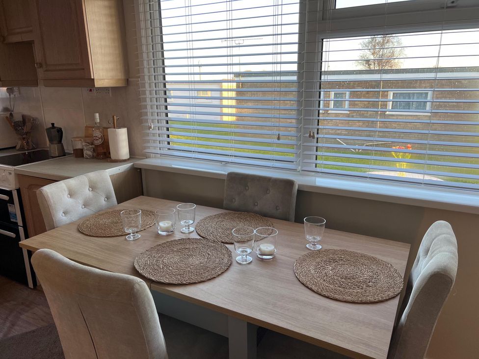 A dining room with a table and chairs at the property in location