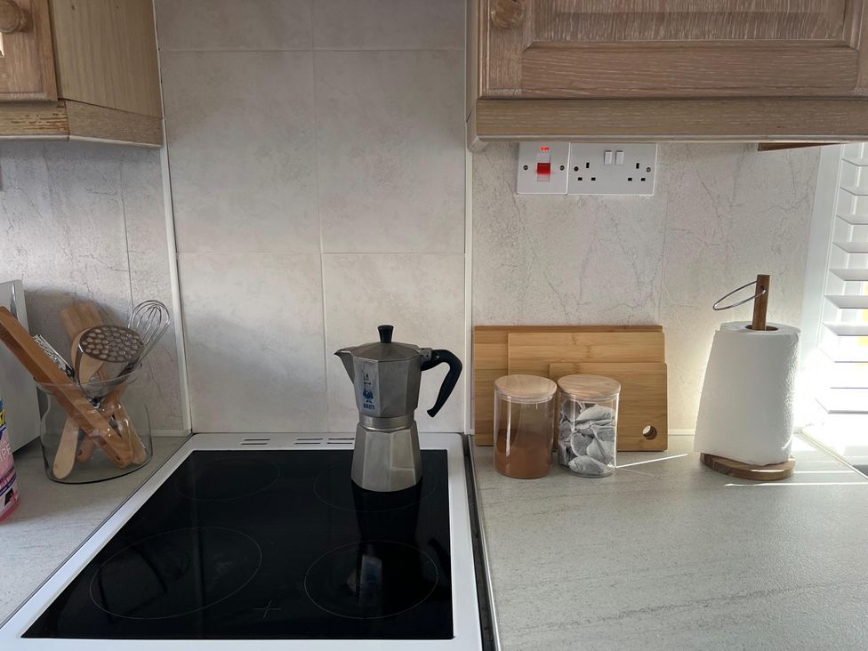 A kitchen counter with a moka pot and utensils at a property in 