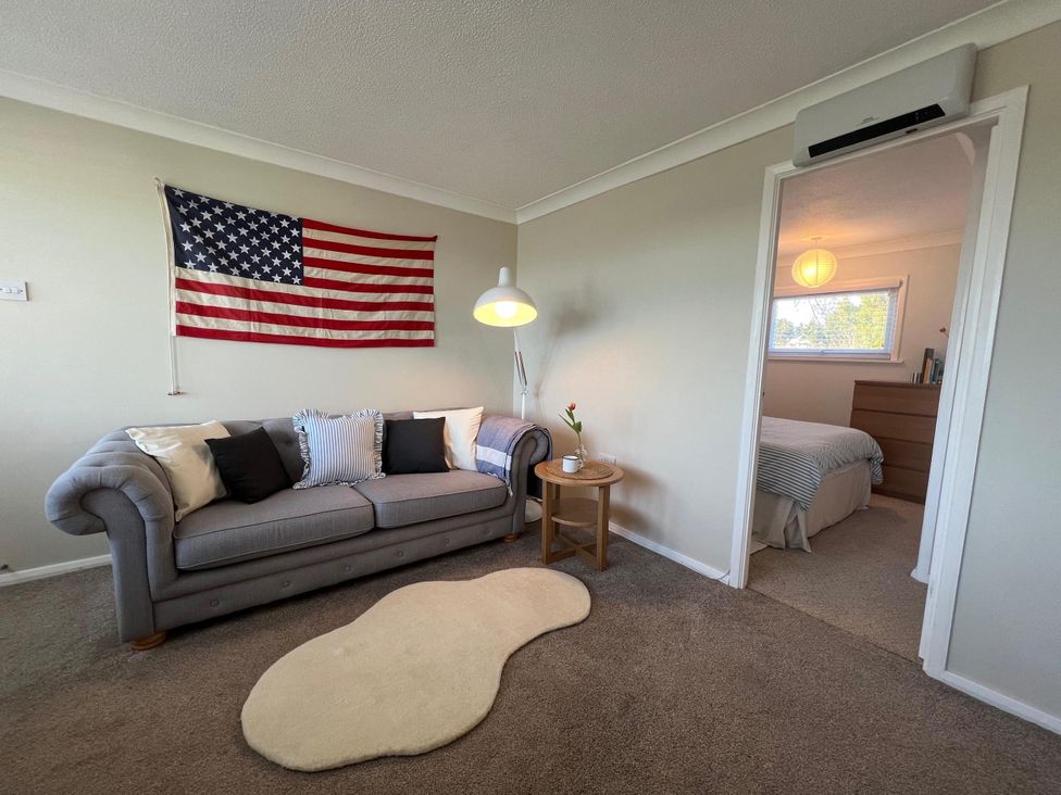 A living room with a flag on the wall and a sofa at The Old Barn in Manchester
