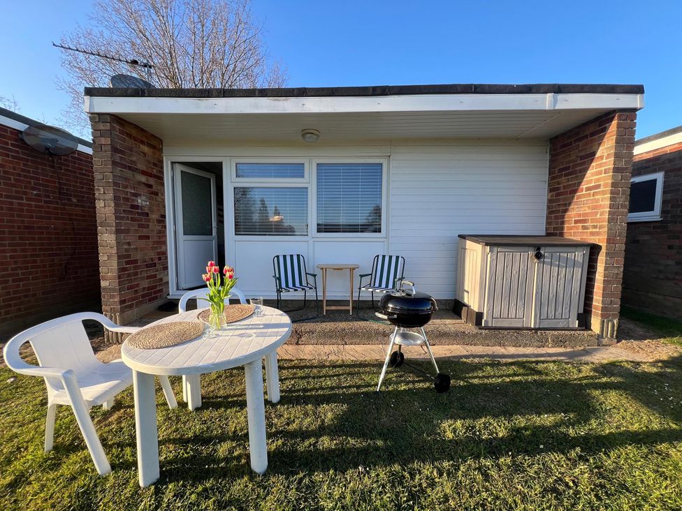 An outdoor area with chairs, table, and barbecue at the property