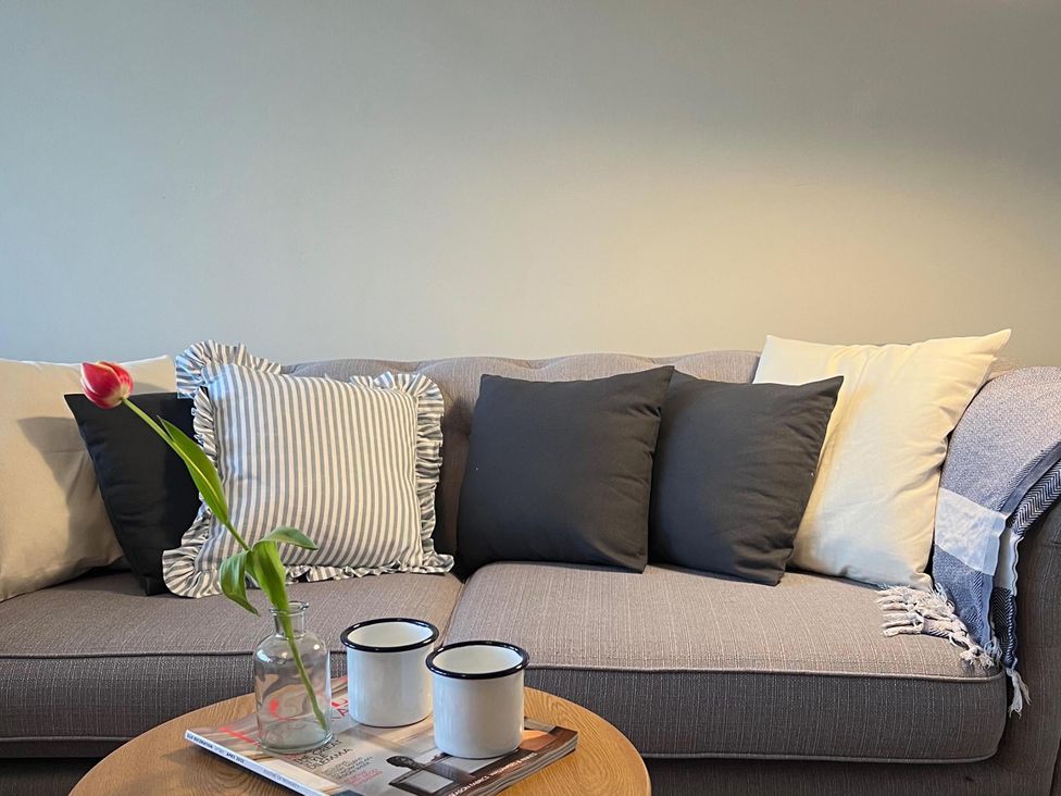 A living room with a sofa and cushions at the property