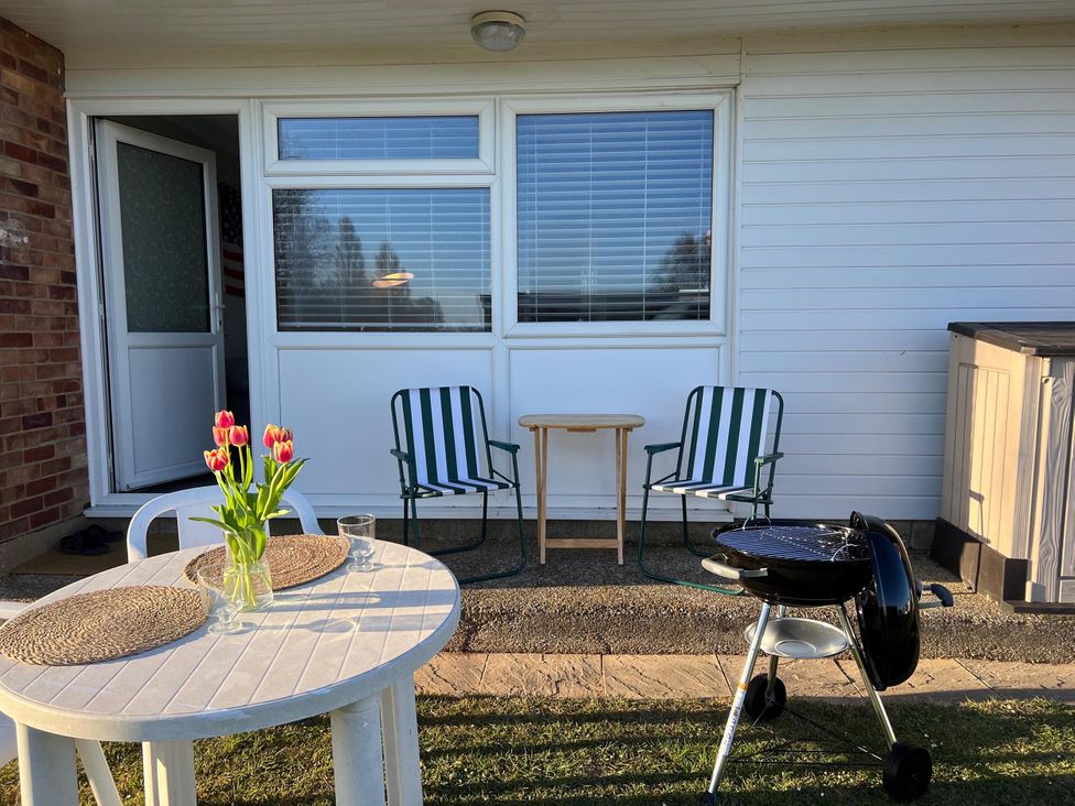 An outdoor space with a table, chairs, and a barbecue at an unspecified location