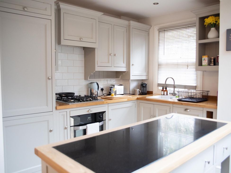 A kitchen with cabinets, stove, sink and appliances at York Minster 3bed Sleeps 6 Fireplace Free Parking, York