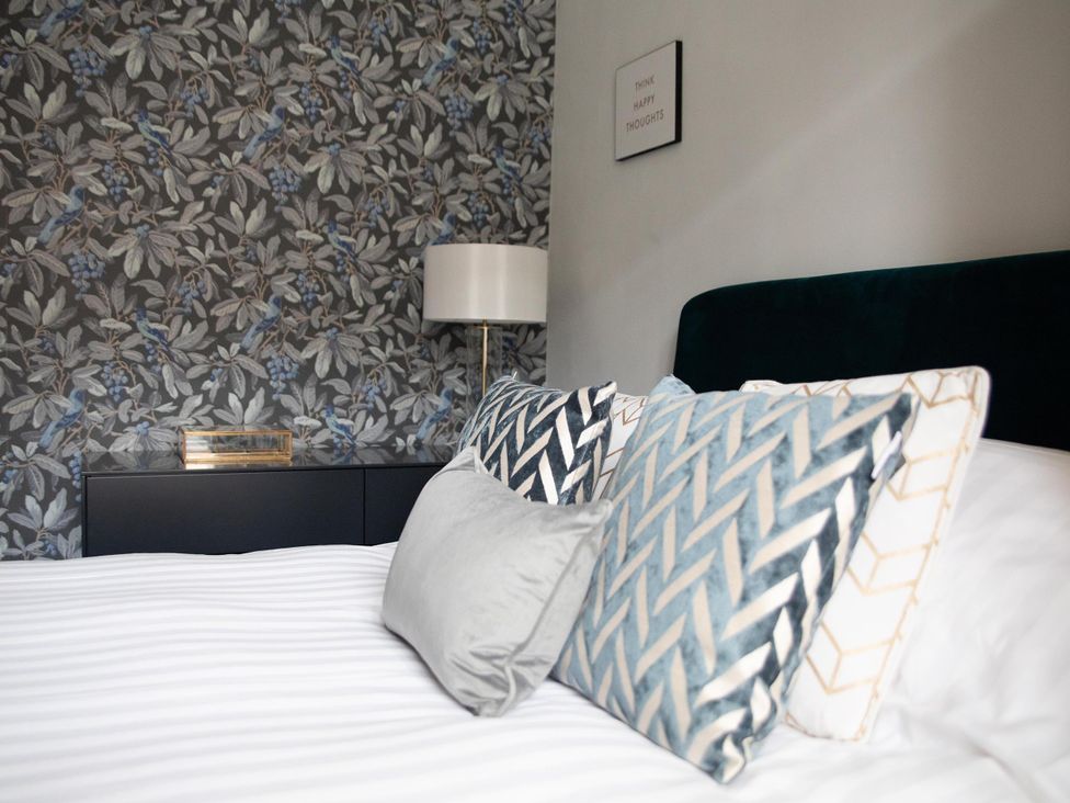 A bedroom with a bed and decorative pillows at York Minster 3bed Sleeps 6 Fireplace Free Parking, York