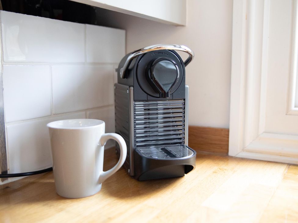 A coffee machine next to a cup at York Minster 3bed Sleeps 6 Fireplace Free Parking, York