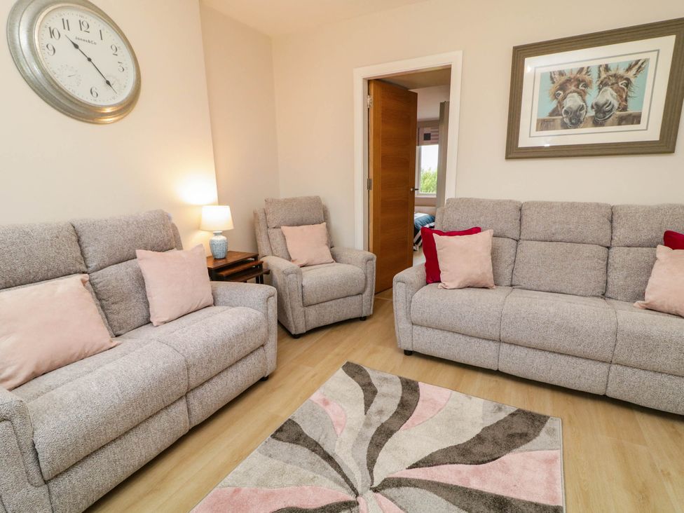 A living room with sofas and a lamp at Biddy Granny's 