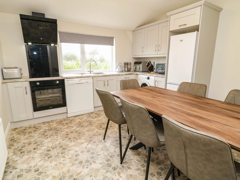 A kitchen with appliances and a dining table at Biddy Granny's