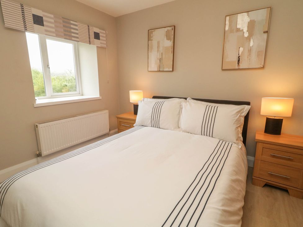 A bedroom with a bed and nightstands at Biddy Granny's
