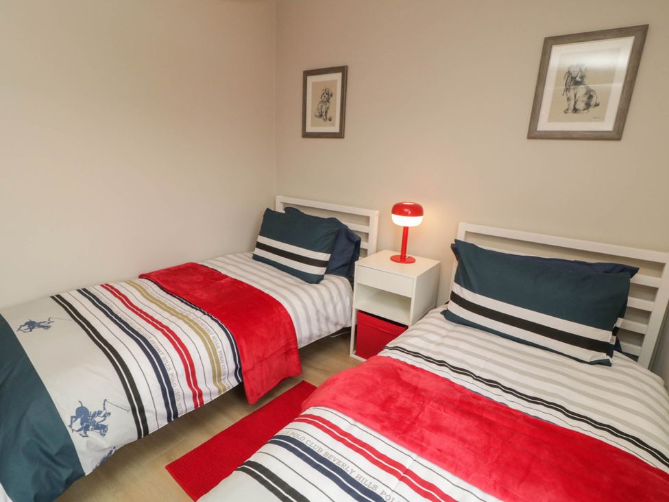 A bedroom with two beds and a nightstand at Biddy Granny's