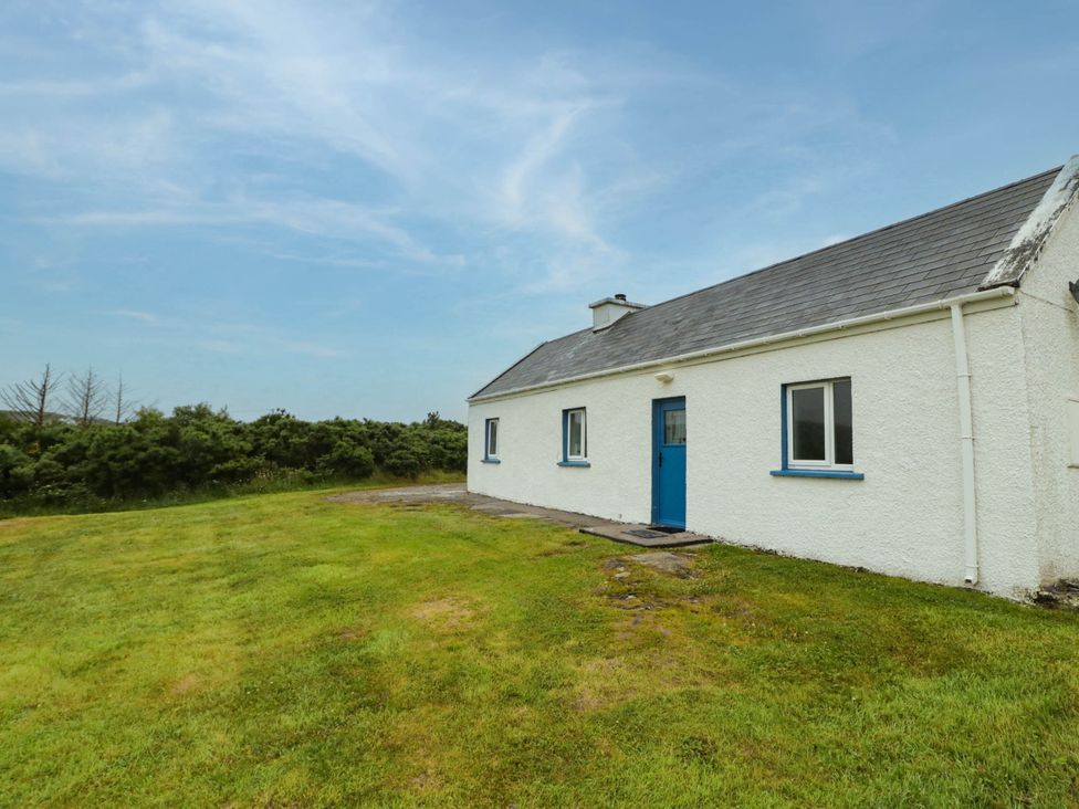 A house with blue door and windows in a grassy area at Biddy Granny's 