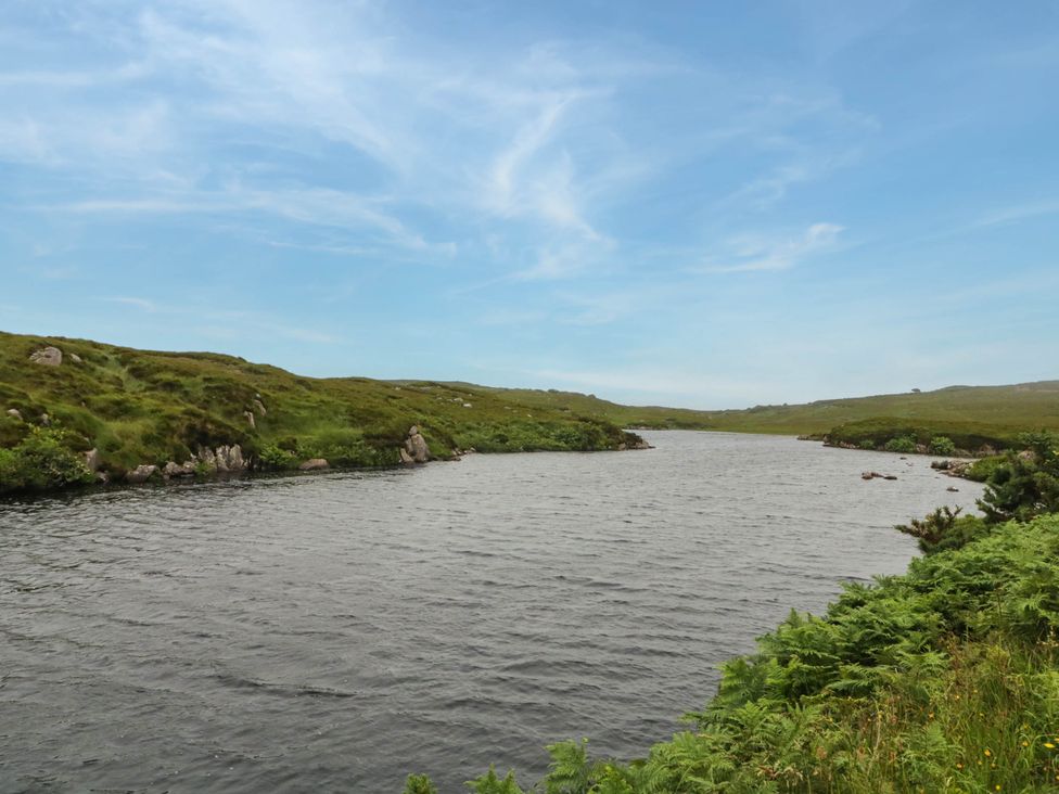 A river surrounded by hills and grass at Biddy Granny's