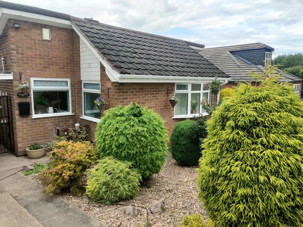 A bungalow with a garden featuring bushes and gravel at Split Level Bungalow Sleeps4 Close to walks Stanton Hill