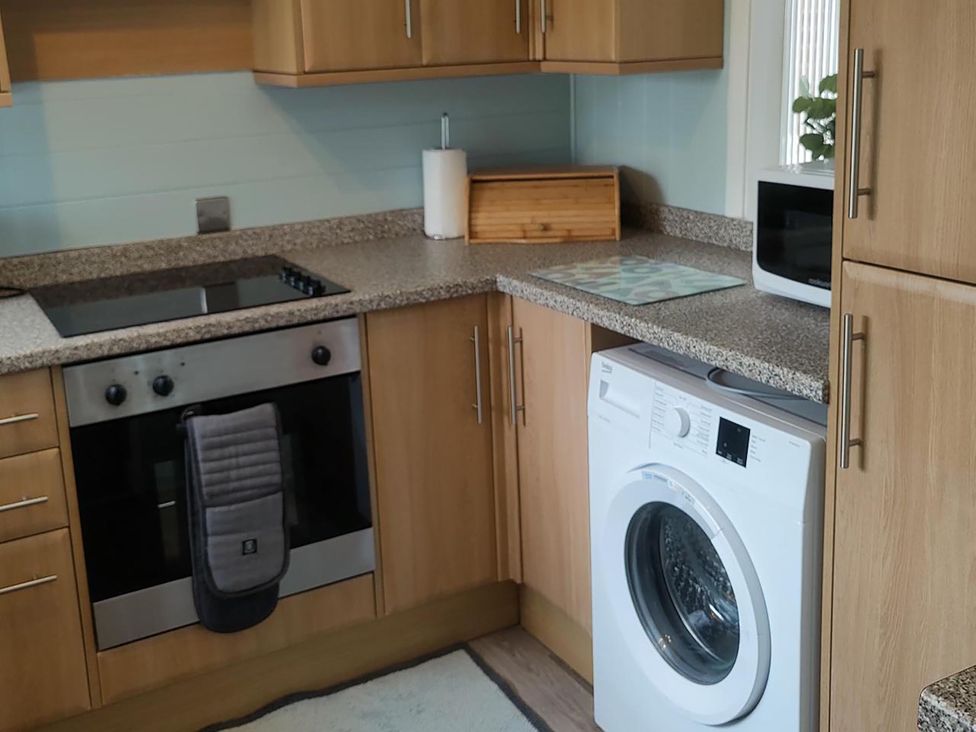 A kitchen with appliances including a washing machine and oven at Split Level Bungalow Sleeps4 Close to walks Stanton Hill