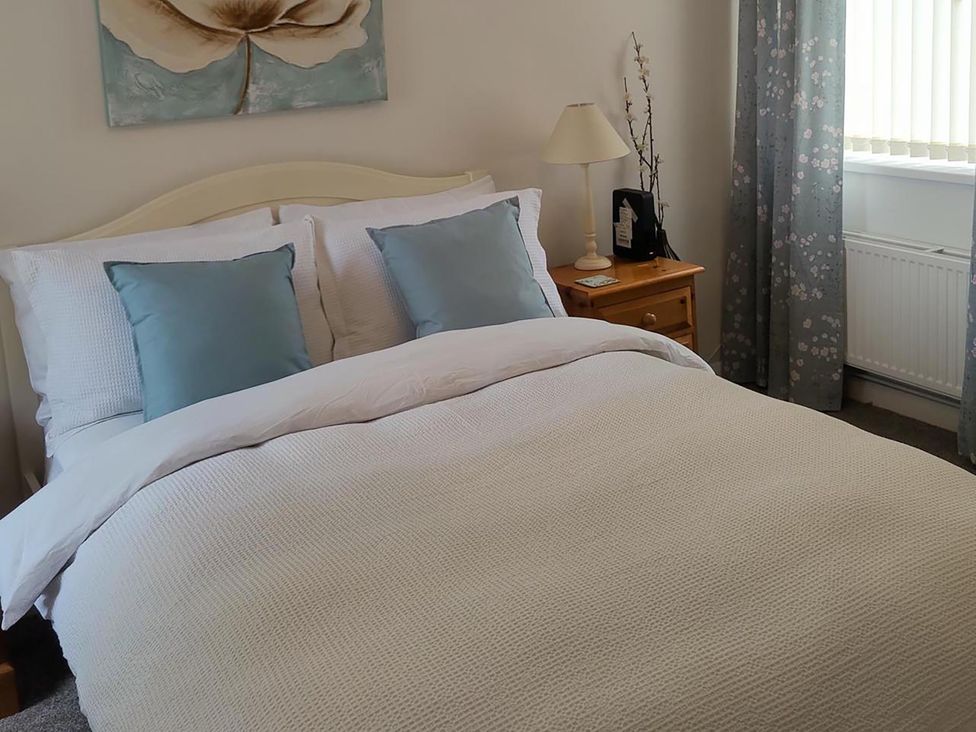 A bedroom with a bed, lamp and nightstand at Split Level Bungalow Sleeps4 Close to walks Stanton Hill