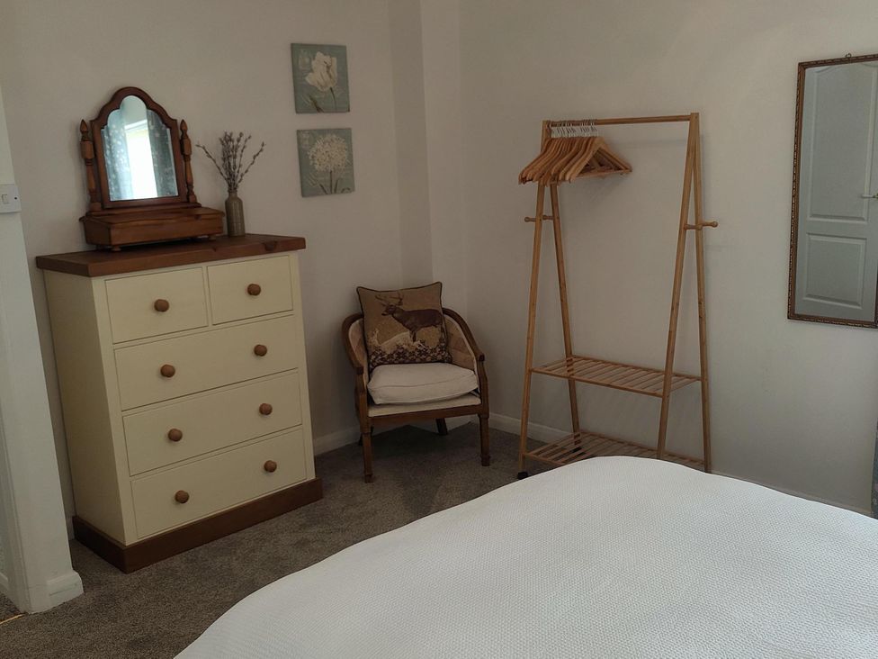 A bedroom with a chest of drawers and a hanging rack at Split Level Bungalow Sleeps4 Close to walks Stanton Hill