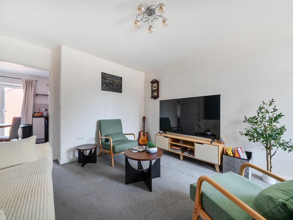 A living room with a television and green chairs at House Sleeps 6 Enclosed Garden Pet Friendly in Bridgwater