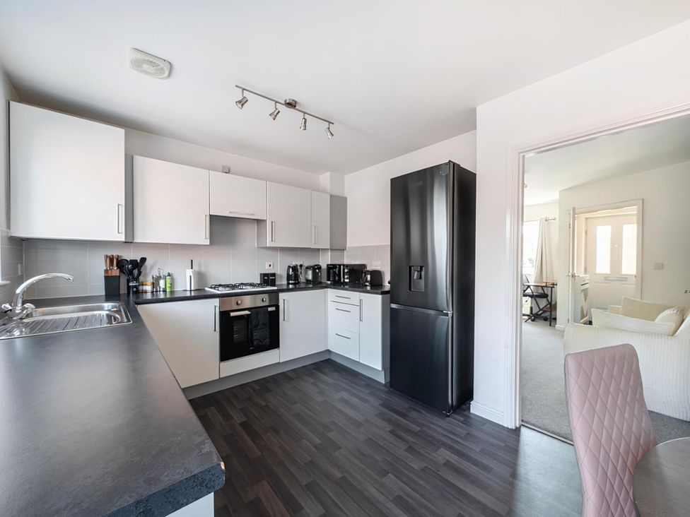 A kitchen with cabinets and refrigerator at House Sleeps 6 Enclosed Garden Pet Friendly in Bridgwater