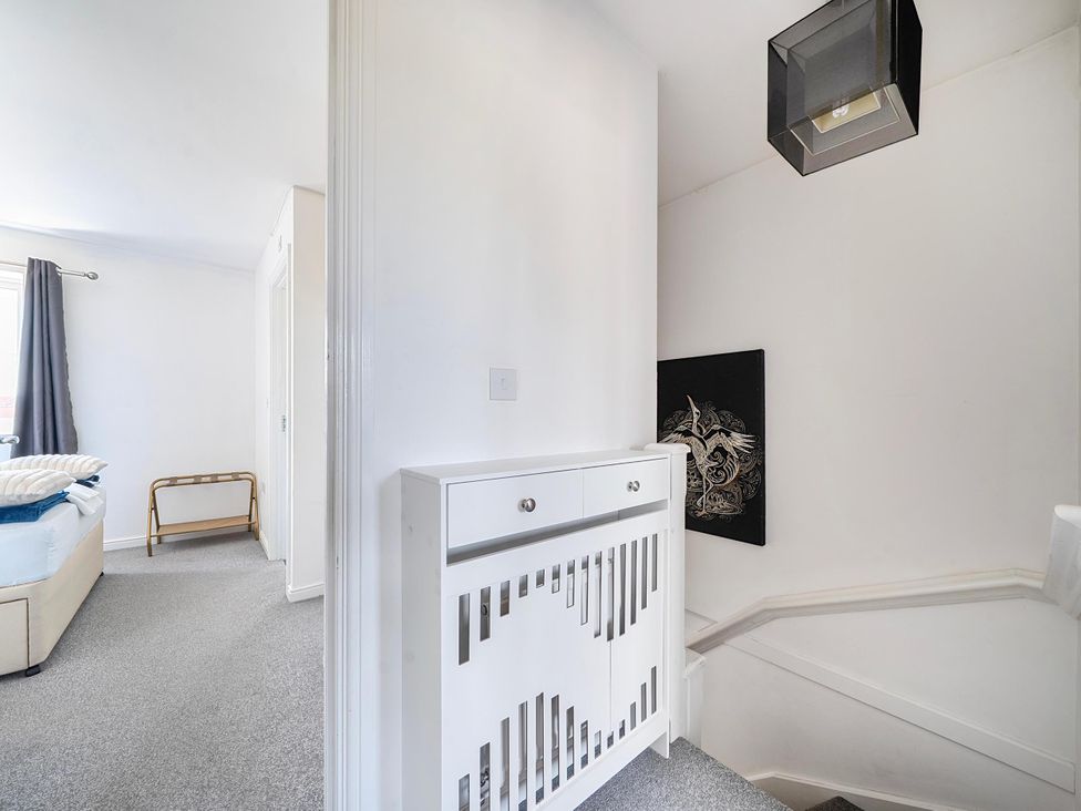 A hallway with a chest of drawers and staircase at House Sleeps 6 Enclosed Garden Pet Friendly in Bridgwater