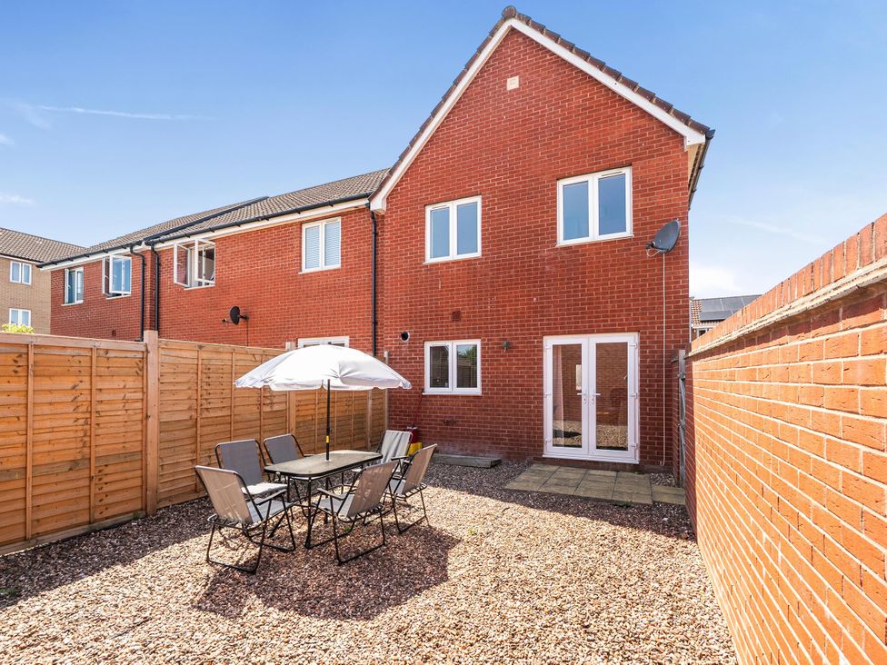 A garden with a table and chairs under an umbrella at House Sleeps 6 Enclosed Garden Pet Friendly, Bridgwater