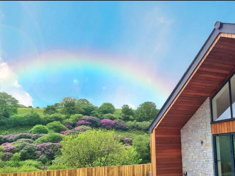 A view of a rainbow over a garden and house at 4 Bed Villa Sleeps 8 Private Terrace Free parking Near St Austell